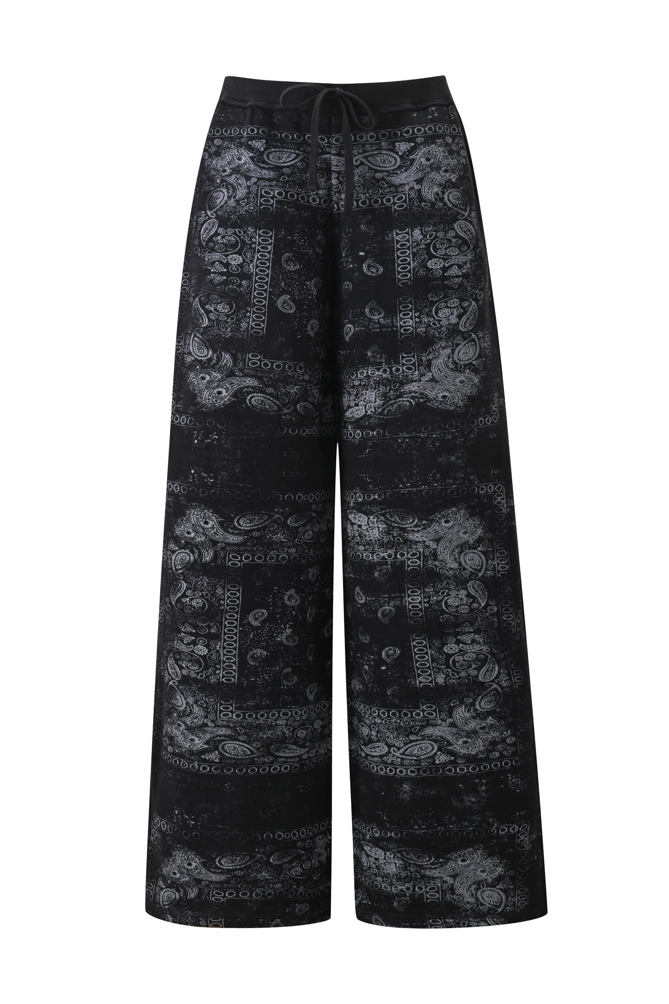The I.AM.GIA T-REX TRACKPANT - BLACK BANDANA showcases a wide-leg street style silhouette with a subtle gray paisley and geometric pattern, complemented by an elastic waistband and drawstring tie, displayed on a white background.