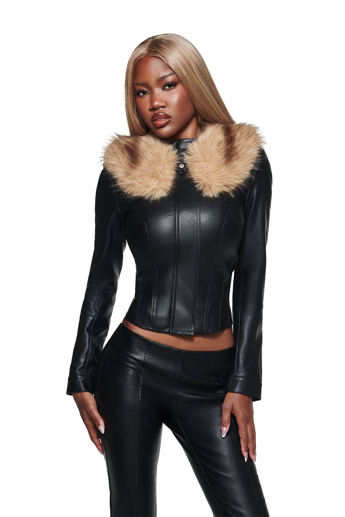 A woman wearing the I.AM.GIA DUA PU JACKET in black, featuring a fitted silhouette with a faux fur collar, poses against a white background with matching black leather pants.