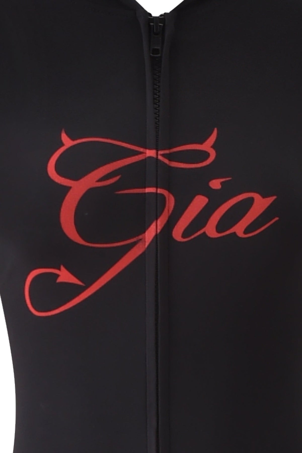 Close-up of the BLARE HORN JUMPSUIT - BLACK by I.AM.GIA, featuring a red cursive logo with a devil tail on the “G,” front vertical zipper, and glimpses of a devil horn hood.