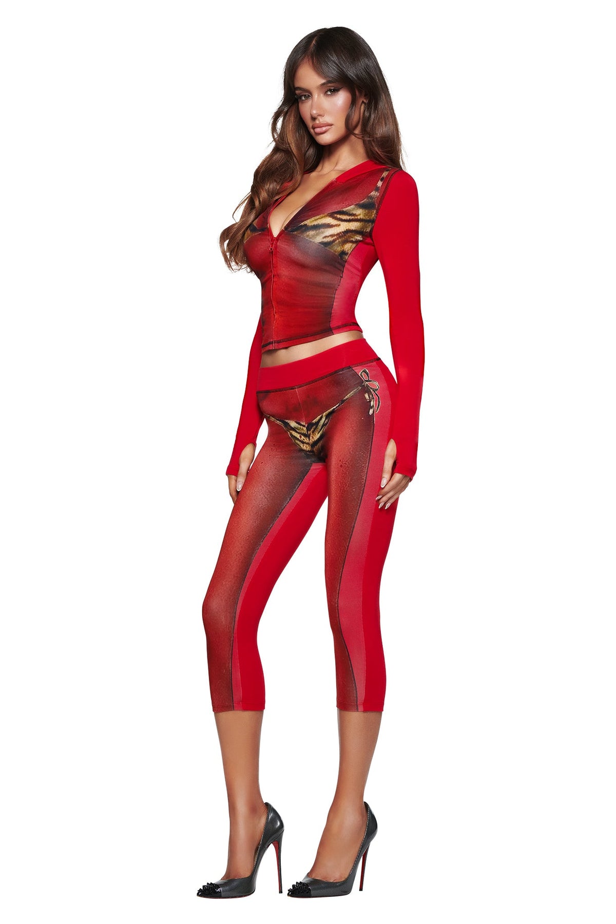 Woman in high heels wears the I.AM.GIA T-REX SPRAY BODY BLARE CAPRI - RED and a deep V-neck top, showing off the bold bikini body print.