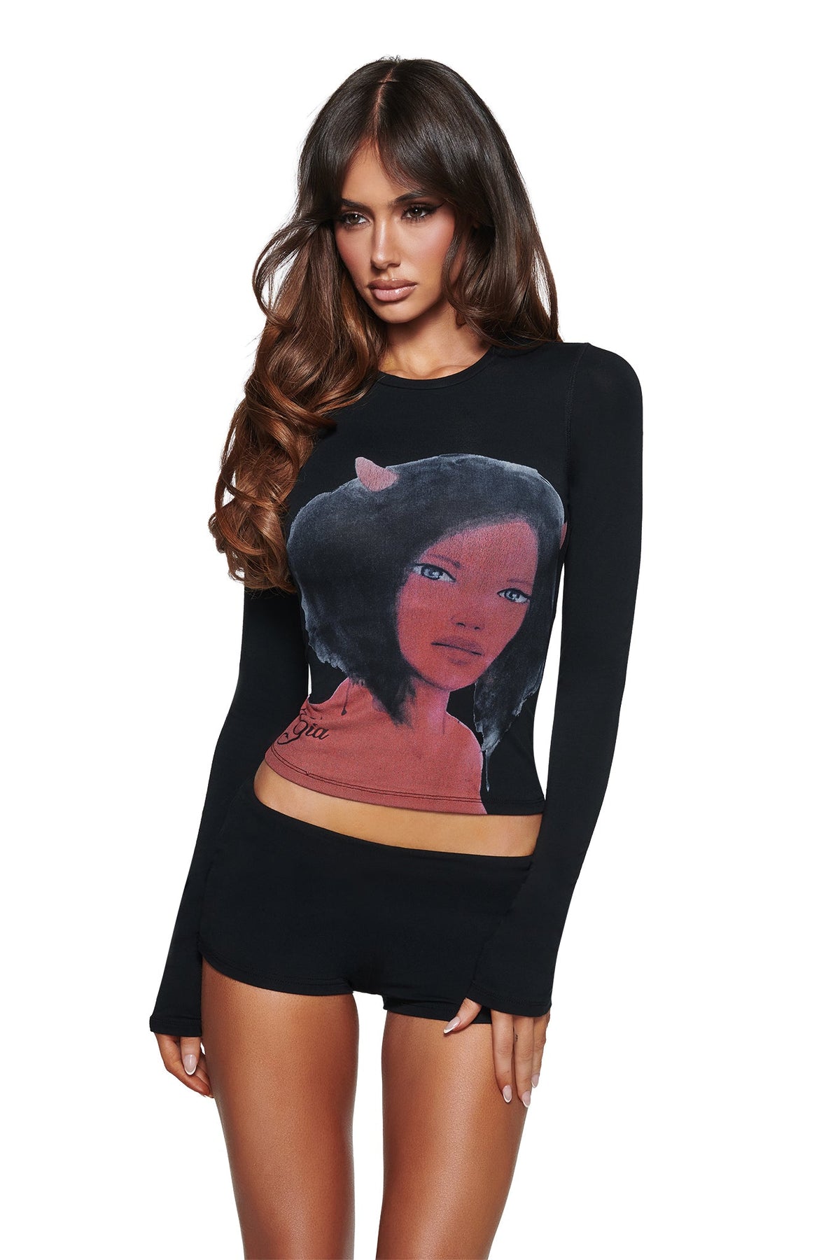 A woman with long brown hair wears the I.AM.GIA T-REX BLARE 2.0 LONG SLEEVE TEE - BLACK, featuring a bold illustrated graphic on the front.