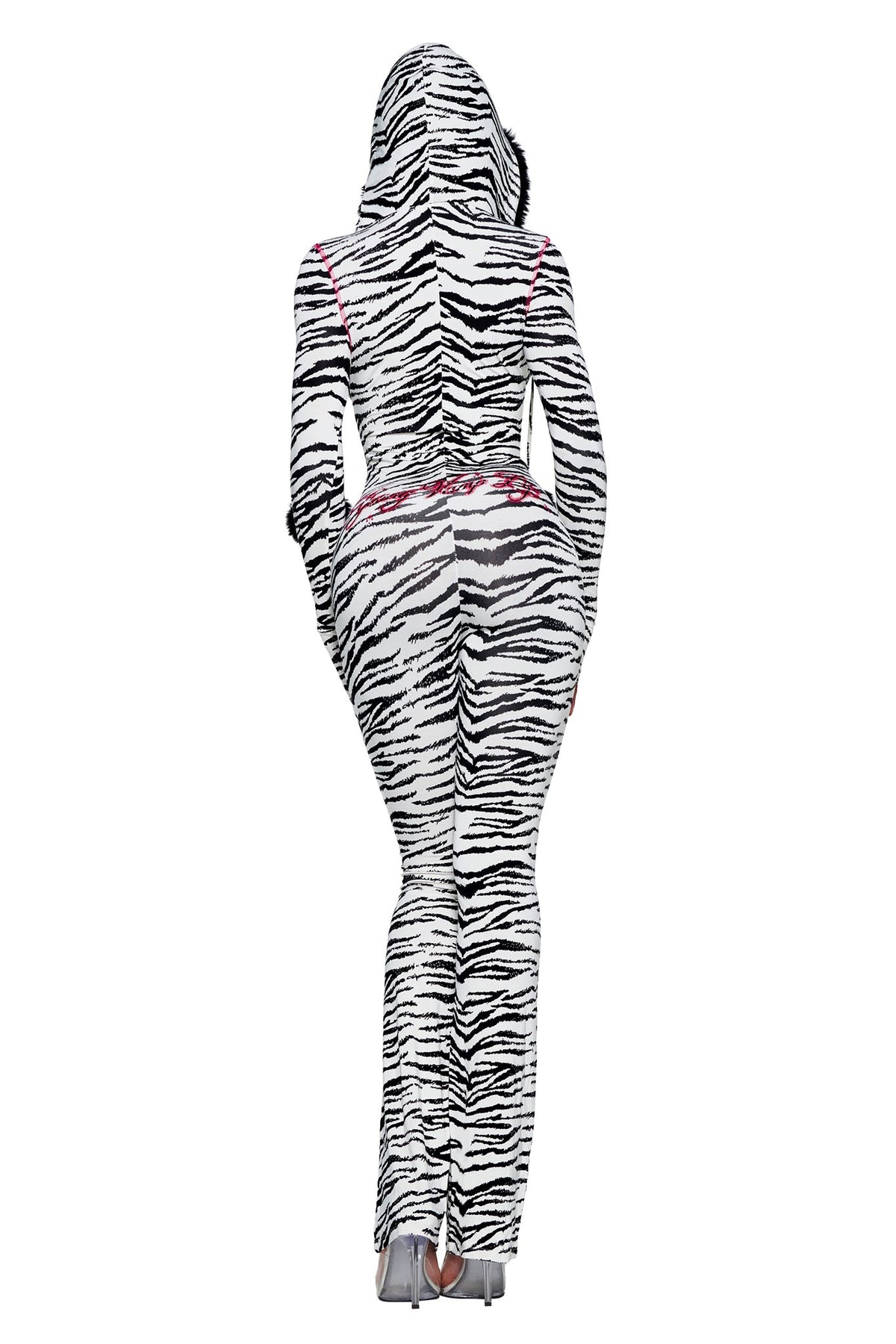 Back view of a person wearing a fitted, zebra-print YVL BLARE FUR LINED JUMPSUIT - ZEBRA with pink stitching and a hood lined with black faux fur.