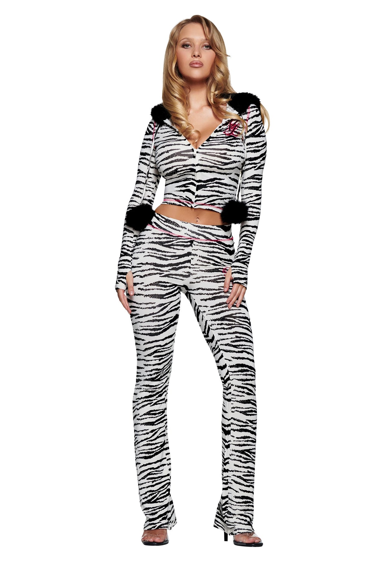 A woman wearing a matching zebra-print zip-up hoodie with black pom-poms and YVL BLARE TRACKPANT - ZEBRA bamboo fabrication flared track pants.