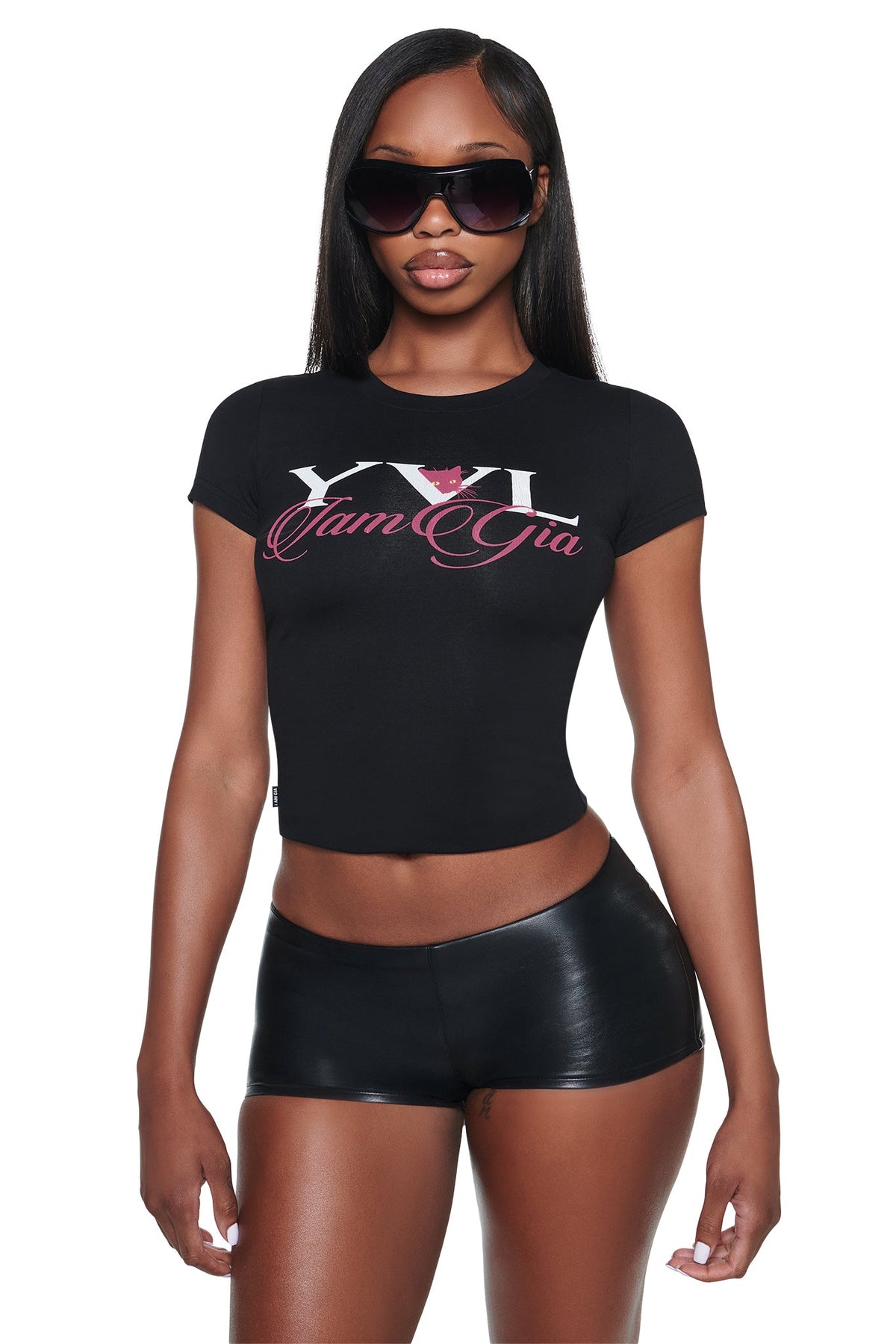 A black short-sleeved YVL T-SHIRT - BLACK CAT by I.AM.GIA, featuring a cropped fit, white “YVL” text, a pink cat icon, and pink cursive branding on the chest.