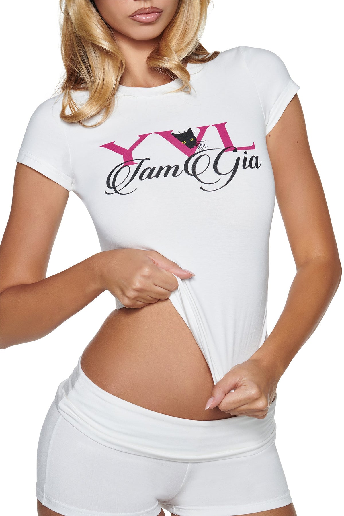 A person wearing a white YVL T-SHIRT - WHITE CAT featuring a black cat graphic and I.AM.GIA script, pulling up the hem of the shirt to reveal their midriff.