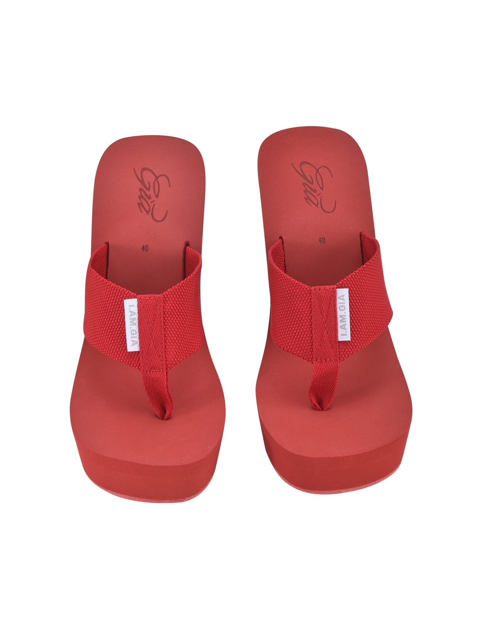 A pair of SHELBY FLIP FLOP - RED with wide mesh straps and a white label featuring the brand name "LAVENTA." Influenced by I.AM.GIA style, these flip-flops have a slightly elevated sole, and the top view displays an elegant cursive logo near the heel area.