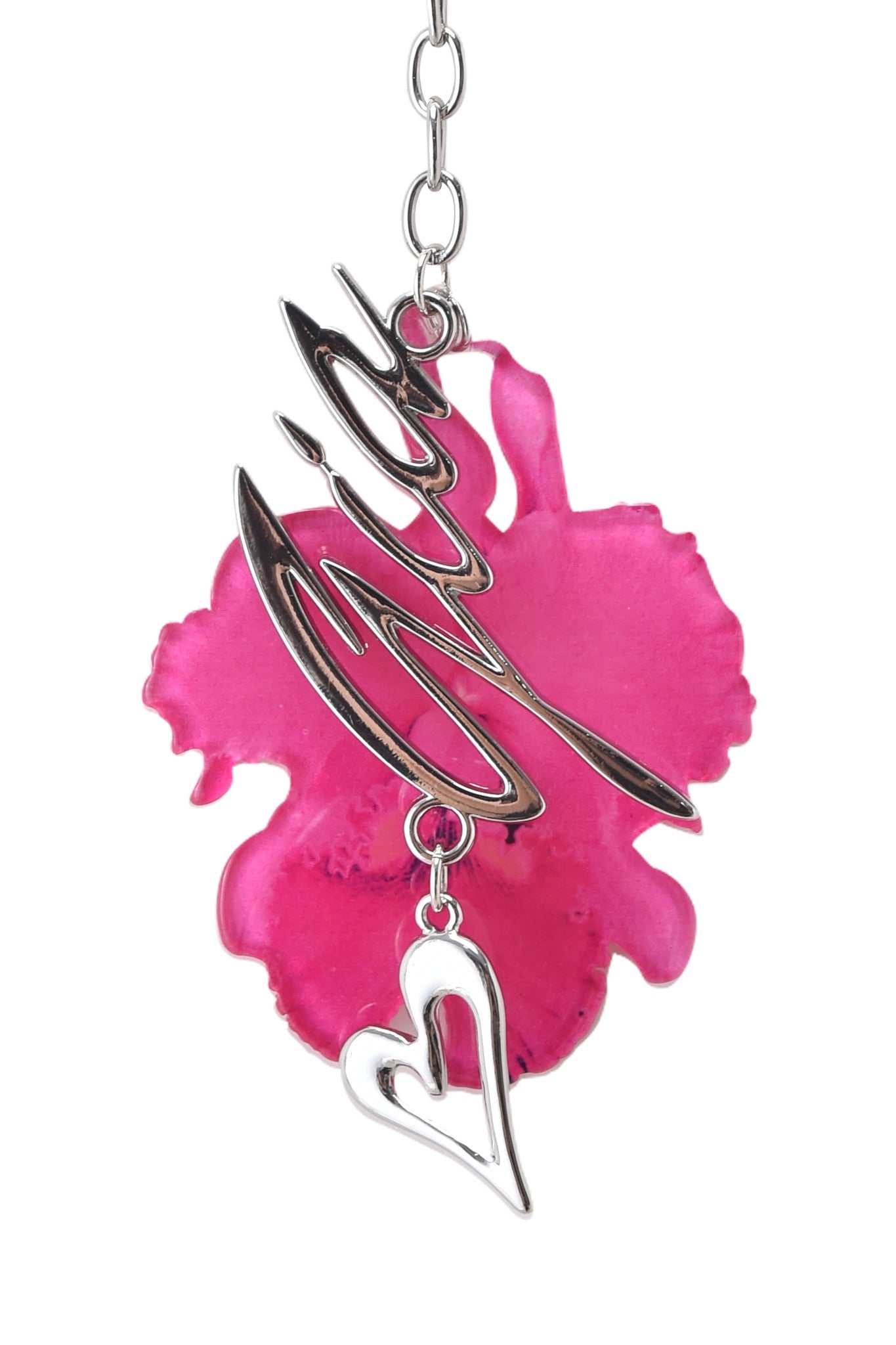 The ORCHID KEYCHAIN - NEON PINK by I.AM.GIA features a silver pendant with cursive text and a heart charm, hanging gracefully in front of a neon pink orchid flower and attached to a delicate chain.
