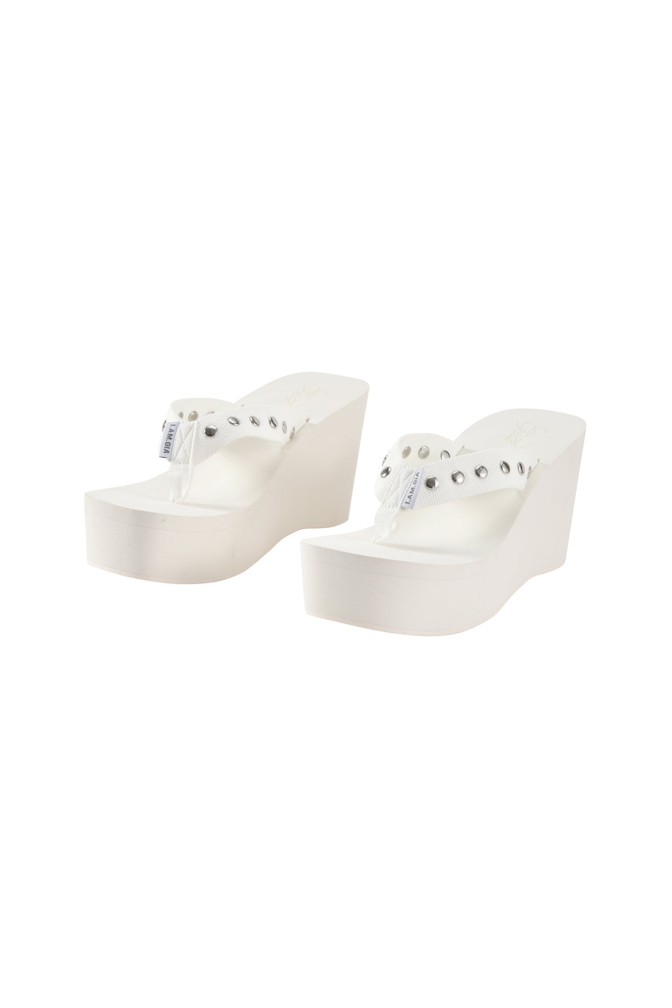 The I.AM.GIA SHELBY STUDDED FLIP FLOP 2.0 in white features clear thong straps and silver studs, shown on a white background.