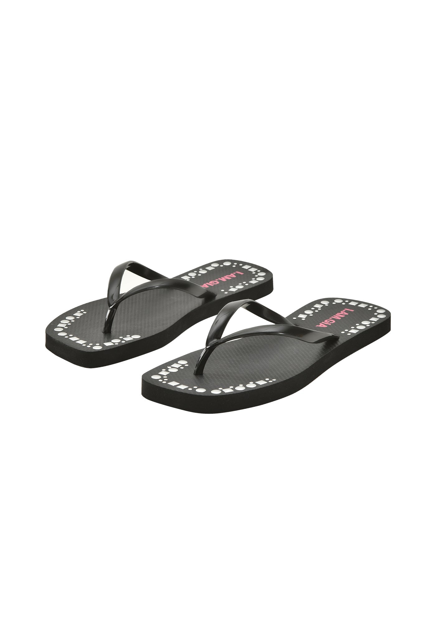 The I.AM.GIA INKA STUDDED FLIP FLOP - BLACK features matching black straps and an extra-soft foam footbed, set side by side on a white background. The sole displays small white shapes with pink text along the edges.