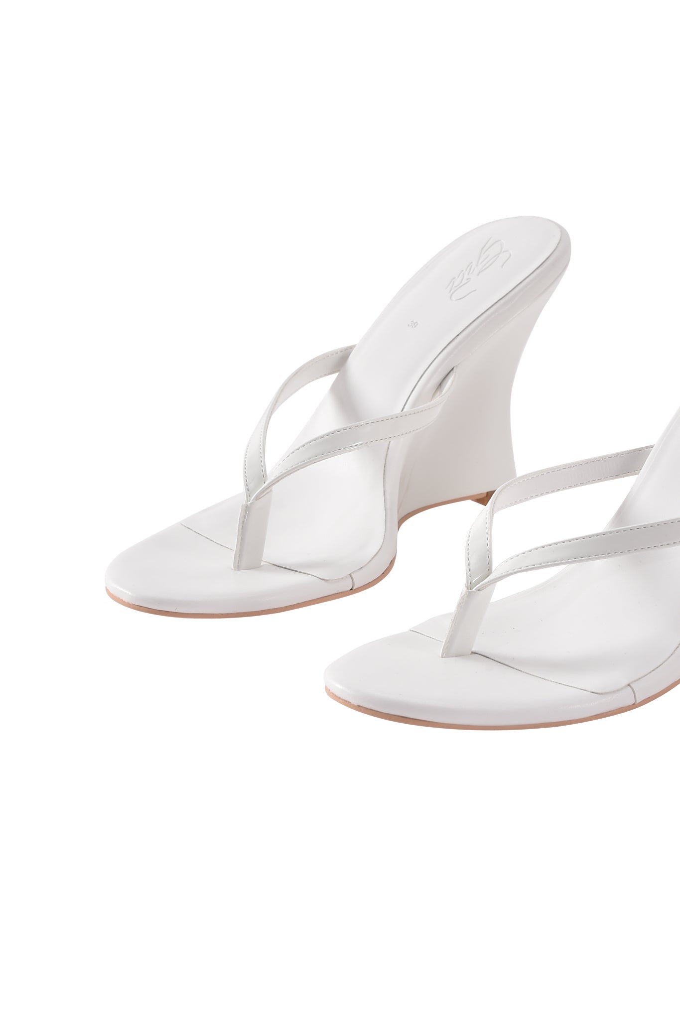The I.AM.GIA VIKTORIA WEDGE HEEL - WHITE features white faux leather with a thong design and slip-on mule style, shown from the front and side against a white background.
