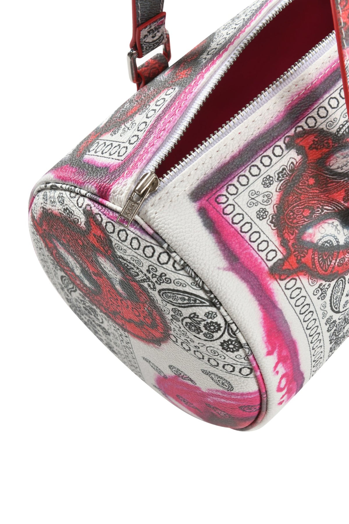 A close-up of the I.AM.GIA T-REX BARREL BAG - PAISLEY FACE, a faux leather purse with a black, white, and pink paisley bandana pattern, silver zipper, and red strap.