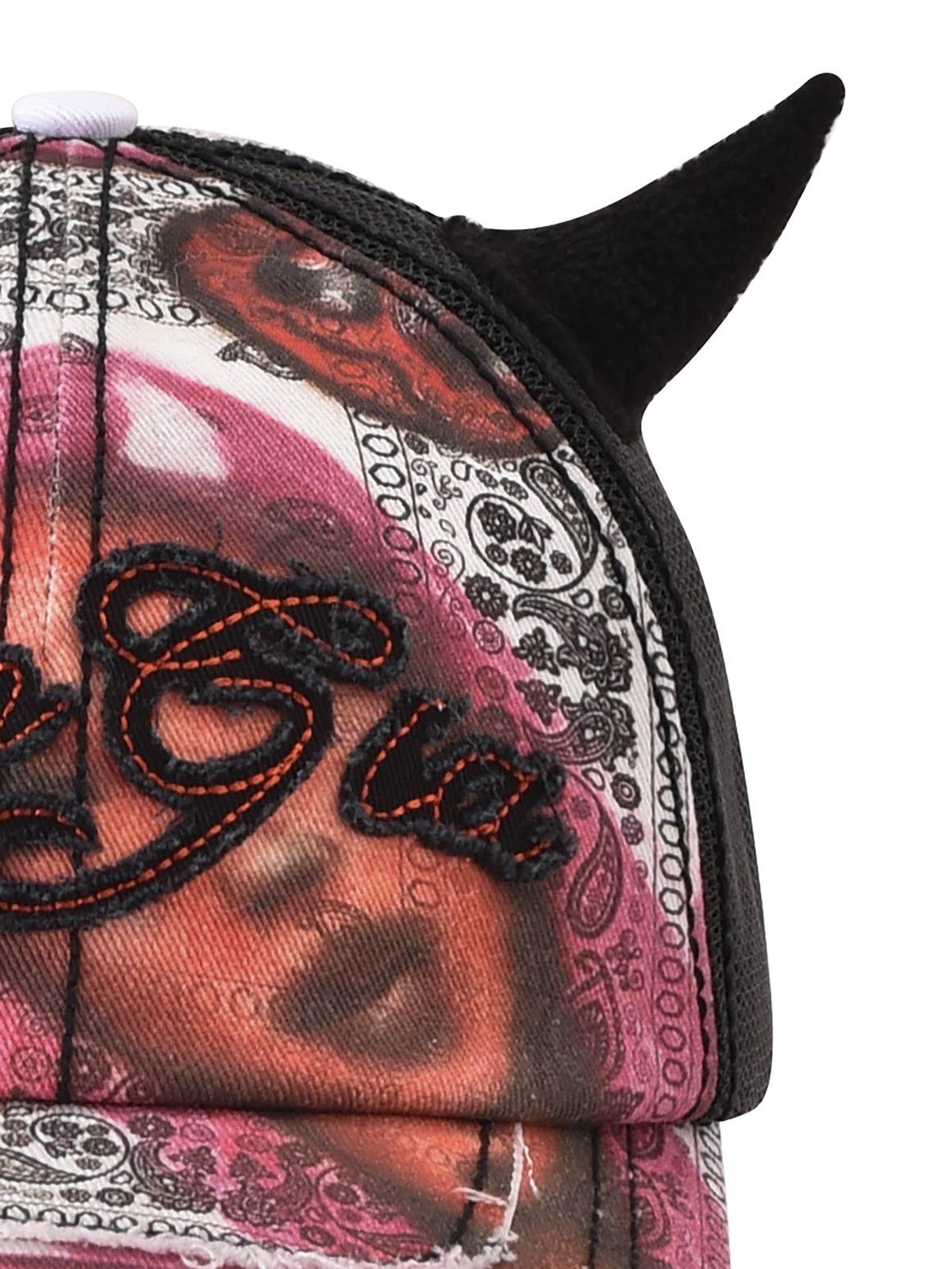 A close-up of the I.AM.GIA T-REX DEVIL HAT - BLACK, featuring black embroidered text, vibrant bandana-style patterns, and black devil horns attached on top.