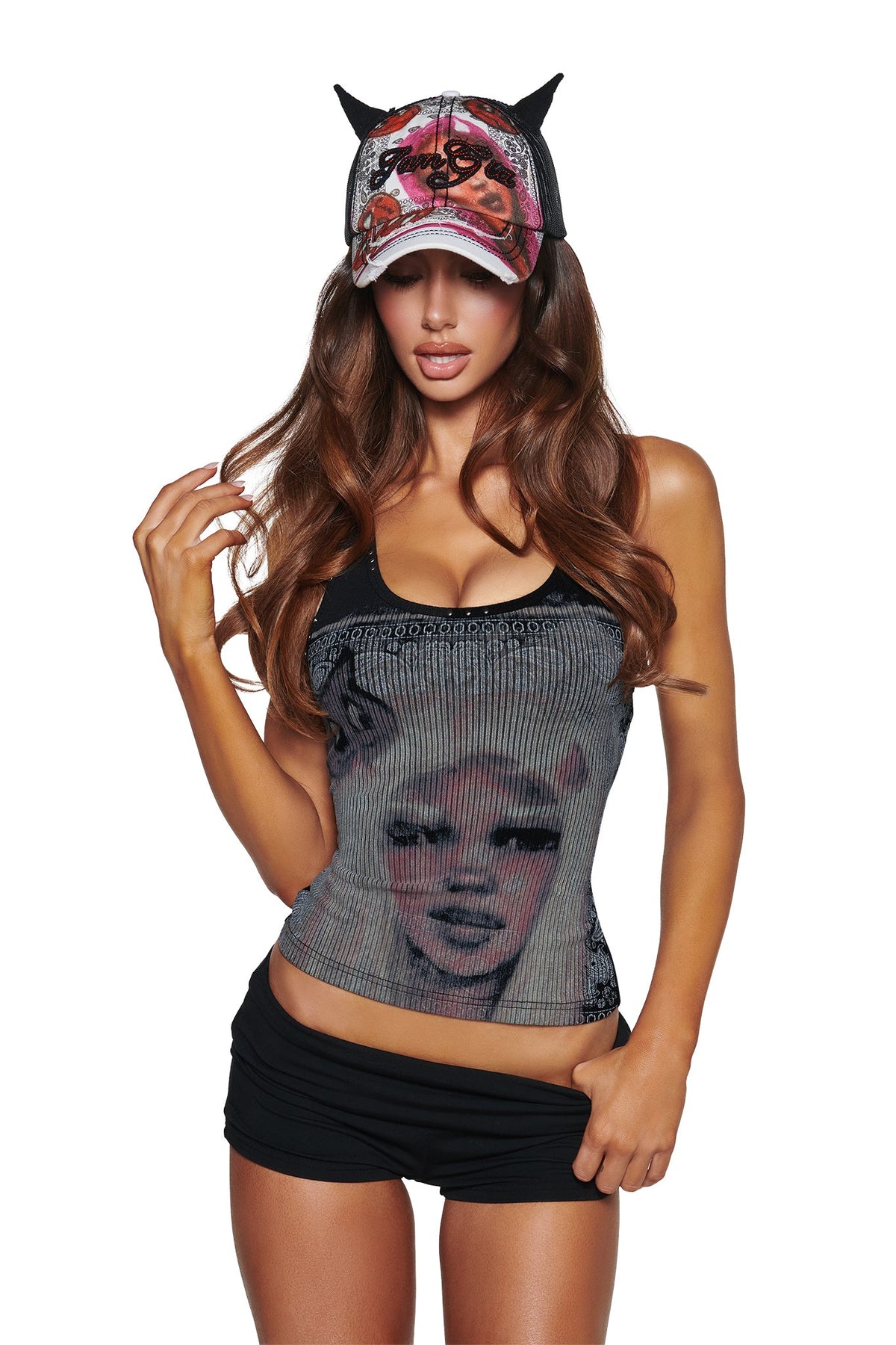 Woman in a black tank, black shorts, and the I.AM.GIA T-REX DEVIL HAT - BLACK. She has long brown hair and poses with one hand in her hair against a white background.