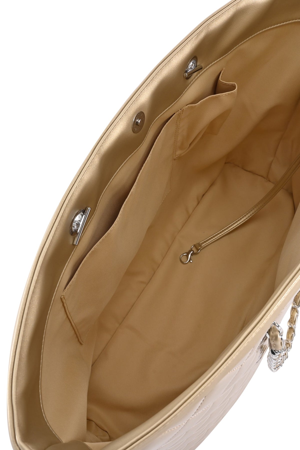 The interior of the I.AM.GIA DANNI TOTE BAG - GOLD features pockets, a zipper compartment, and a small clasp hook; its quilted exterior and elegant chain link straps are partially visible.