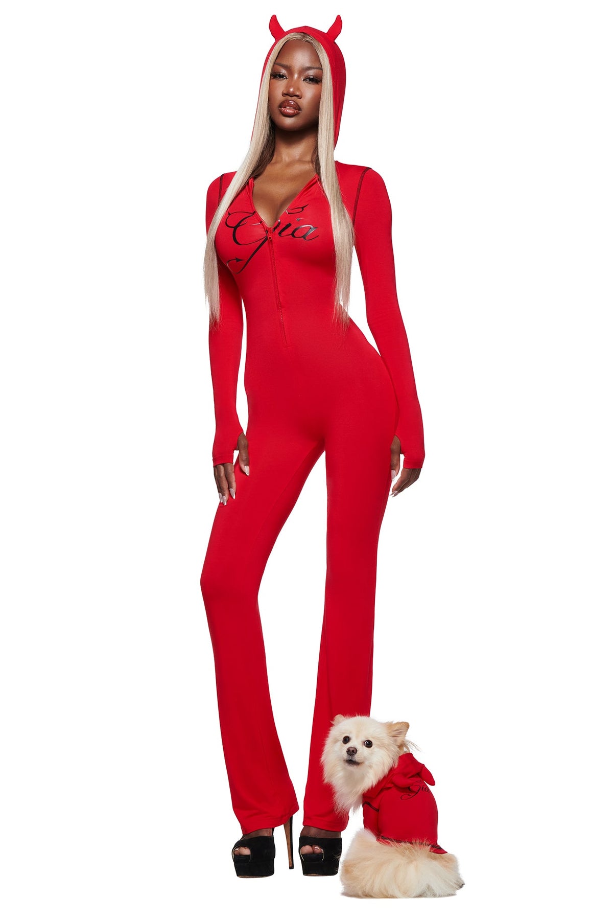 A woman and her small white dog pose playfully in matching red I.AM.GIA T-REX BEST FRIEND BLARE HORN DOG HOODIE - RED outfits against a white background.