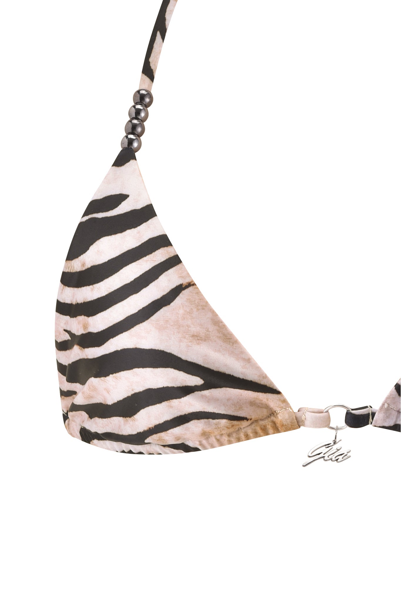 Close-up of the I.AM.GIA LUMANI BIKINI TOP - WILD SIDE featuring zebra-print black and white stripes, strap beads, and a metallic tag with cursive script—a bold animal print swimwear piece.