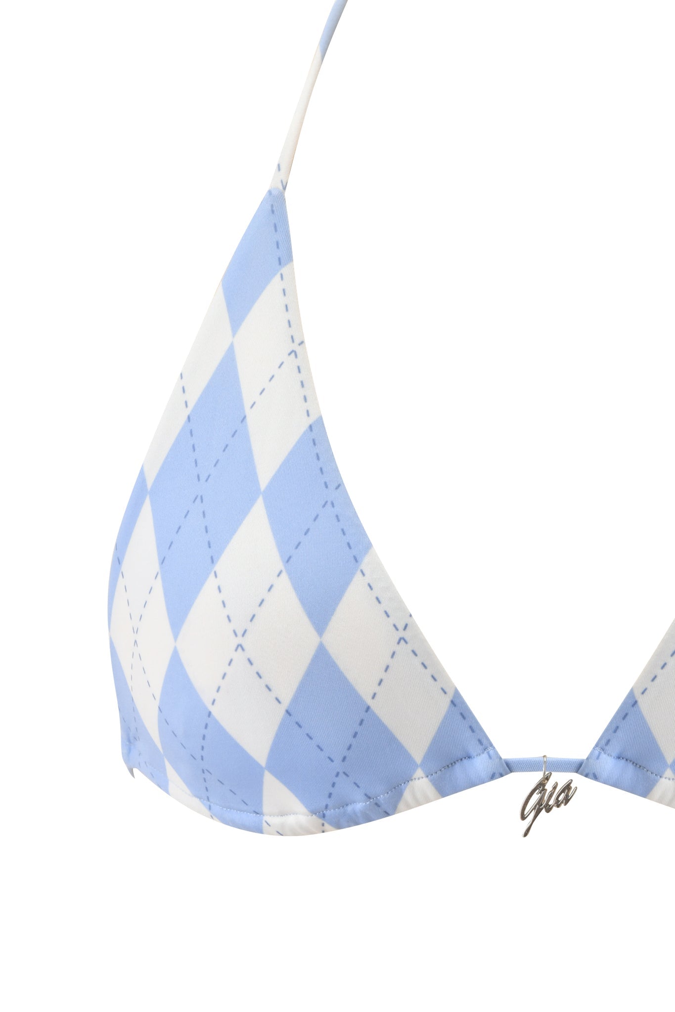 Close-up of the BRITT BIKINI TOP - BLUE ARGYLE by I.AM.GIA, featuring a blue and white argyle print with diamond shapes, dotted lines, a halter neck, and a “gia” metal charm at the center.