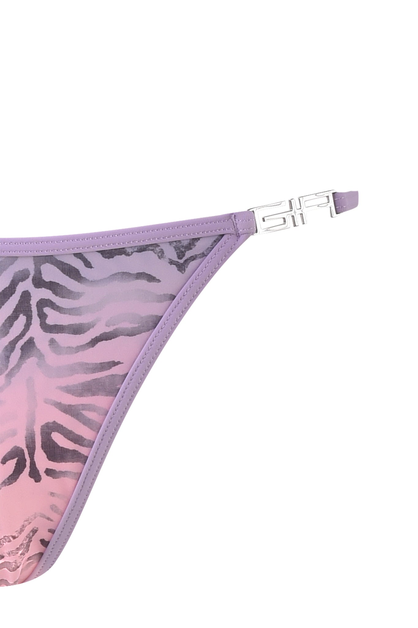 A close-up of the right side of a women's I.AM.GIA AVA BIKINI BOTTOM - PURPLE : ZEBRA, showcasing a zebra ombre print in shades of purple and pink. The G-string style bikini features thin straps with metallic buckle detailing.