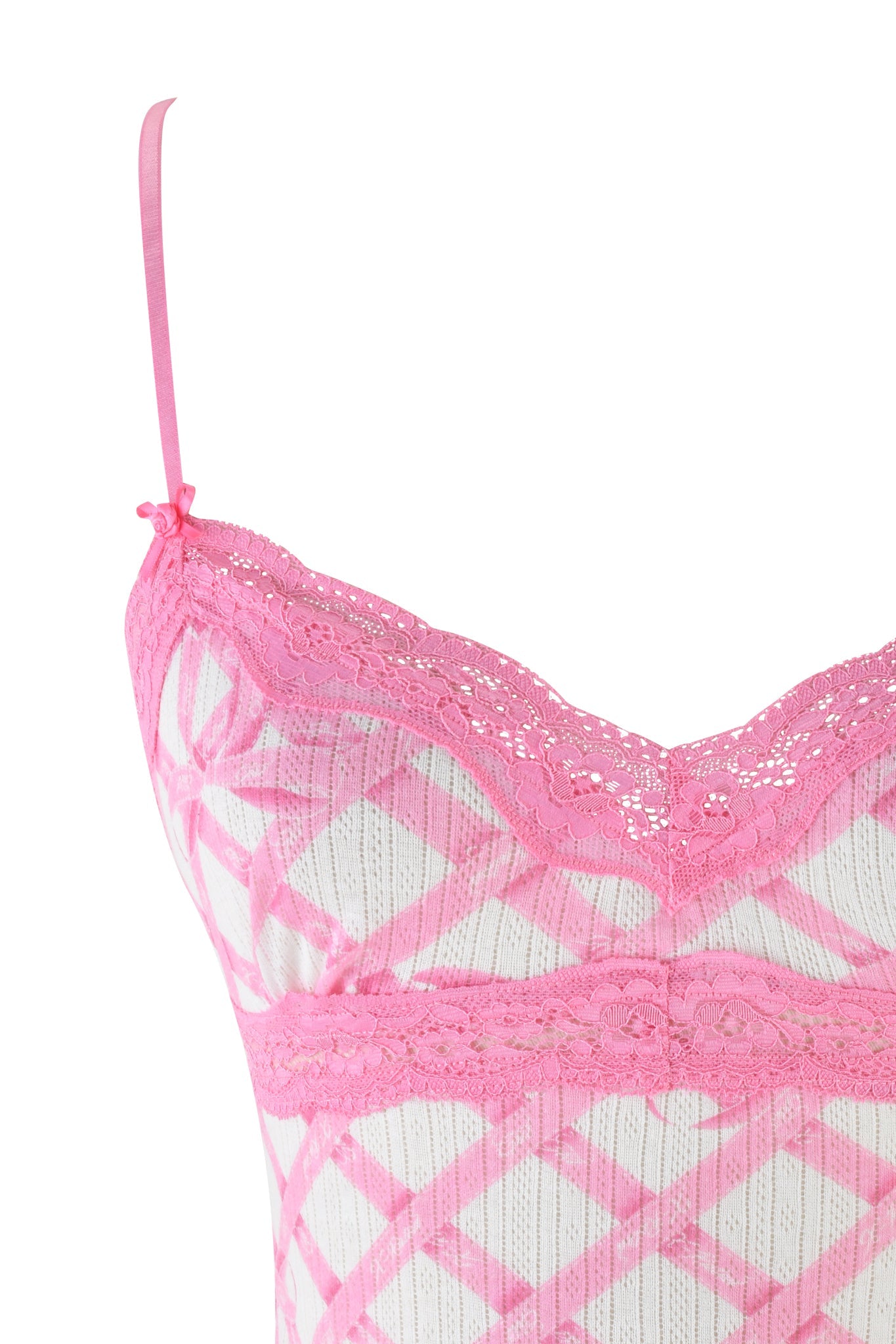 A close-up of the I.AM.GIA CASSIA TOP in pink shows its delicate lace on the bust, thin straps, diamond-pattern pointelle knit fabric, floral lace trim, and a small bow on the strap for a feminine touch.