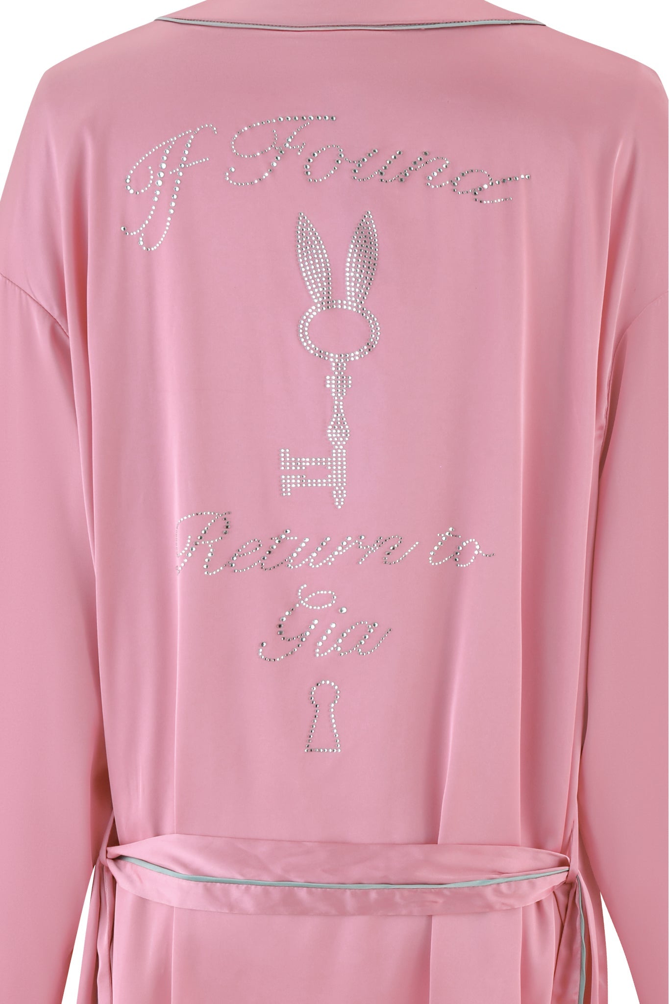 The MARTINA SLEEP ROBE - PINK by I.AM.GIA is a silky satin robe adorned with rhinestone embellishments spelling "If Found Return to Gia." It showcases a dazzling keyhole and a stylized key with bunny ears design. This custom GIA diamante piece features a relaxed fit and comes with a waist belt.