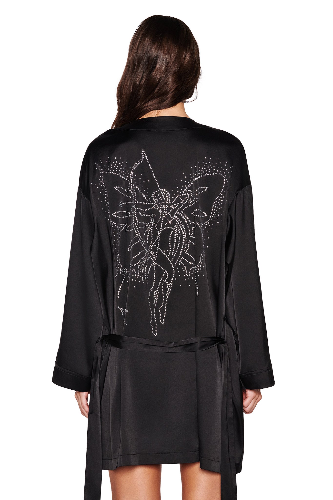 The person with long hair is seen from the back, wearing the I.AM.GIA LARSA 2.0 SLEEP ROBE in black, featuring a satin texture and adorned with a dazzling butterfly diamante artwork of a fairy.