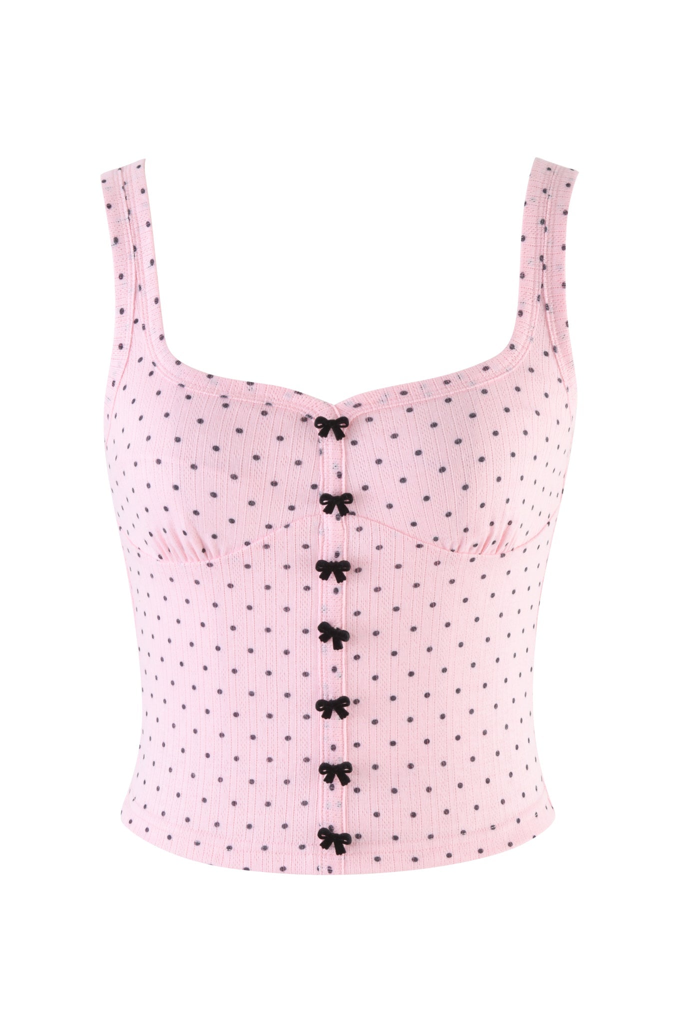 The I.AM.GIA LAUREL TANK in light pink is a sleeveless, body-con crop top with black front bows, ribbed texture, and a flattering fit. Polka dot design on a white background.