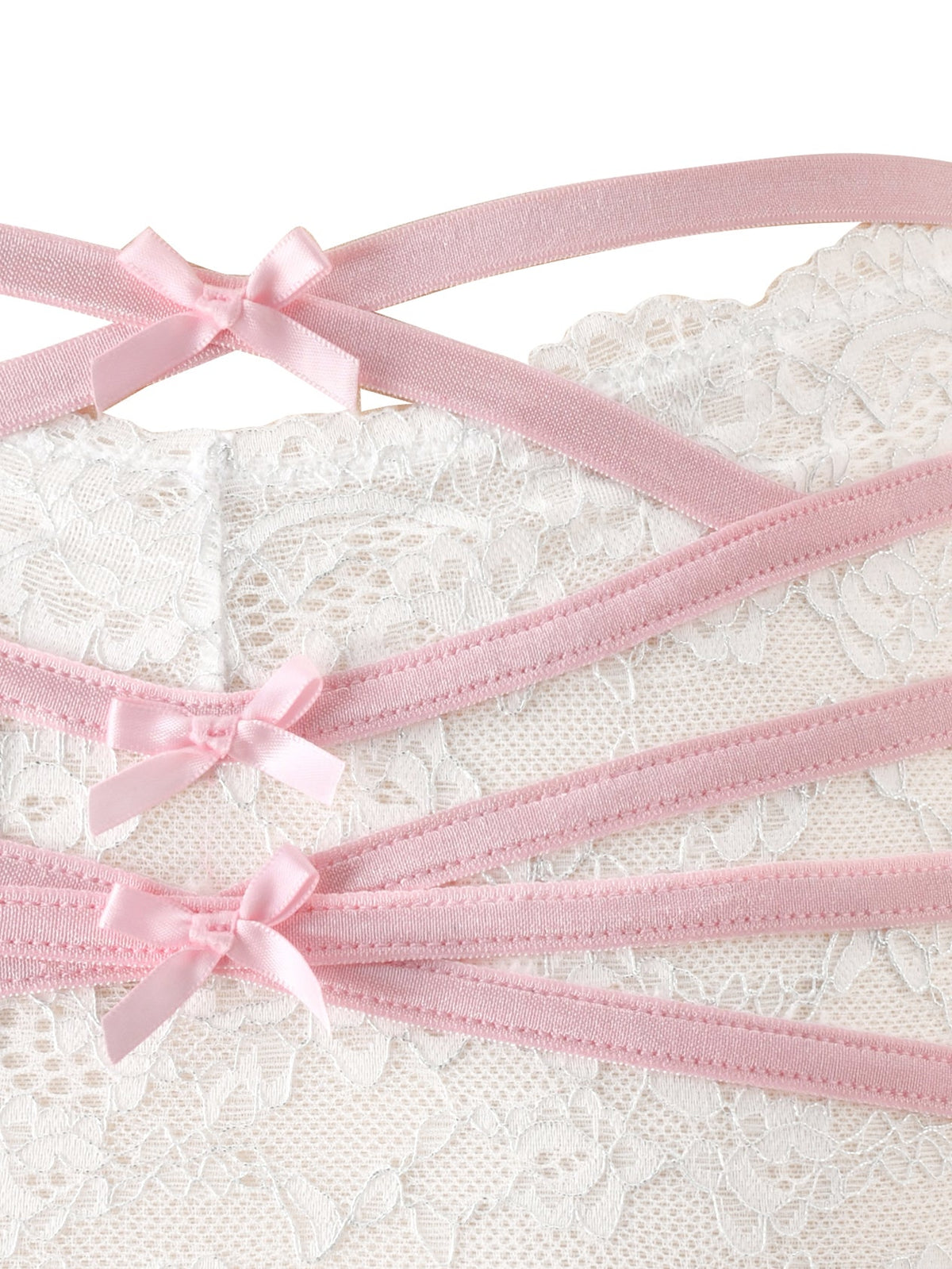 Close-up of the BUNNY LINGERIE SET - WHITE PINK by I.AM.GIA, showcasing vintage-inspired white lace with four parallel pink satin straps, each detailed with a small pink bow, arranged diagonally across the image.