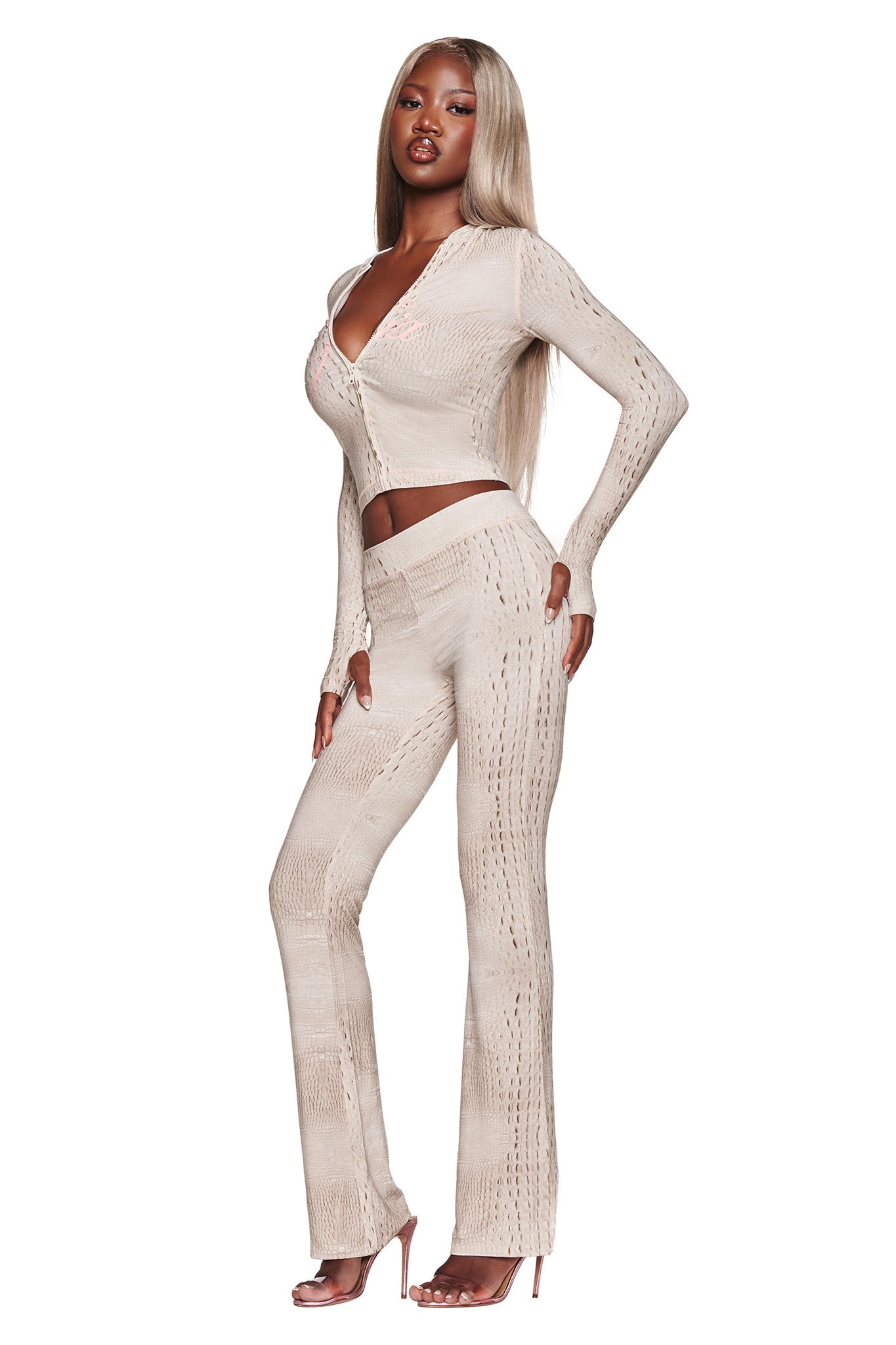 A woman with long, straight blonde hair wears the I.AM.GIA BLARE HOODIE in Hot Croc, styled with nude high heels, posing against a white background.