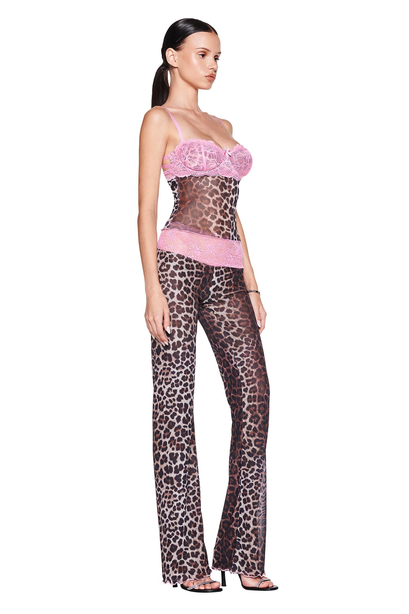 A woman models the I.AM.GIA SILO TOP in classic leopard print with pink lace accents, paired with a matching set and black heels against a white background.