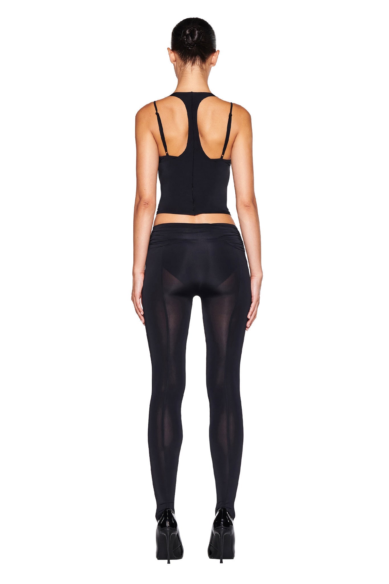Image of the NERINA TIGHTS - BLACK by I.AM.GIA. These high-waisted leggings feature a bodycon fit with smooth, slightly sheer fabric on the lower legs. The wide waistband is ruched at the sides for added detail, providing a sleek and snug fit designed for both comfort and style.