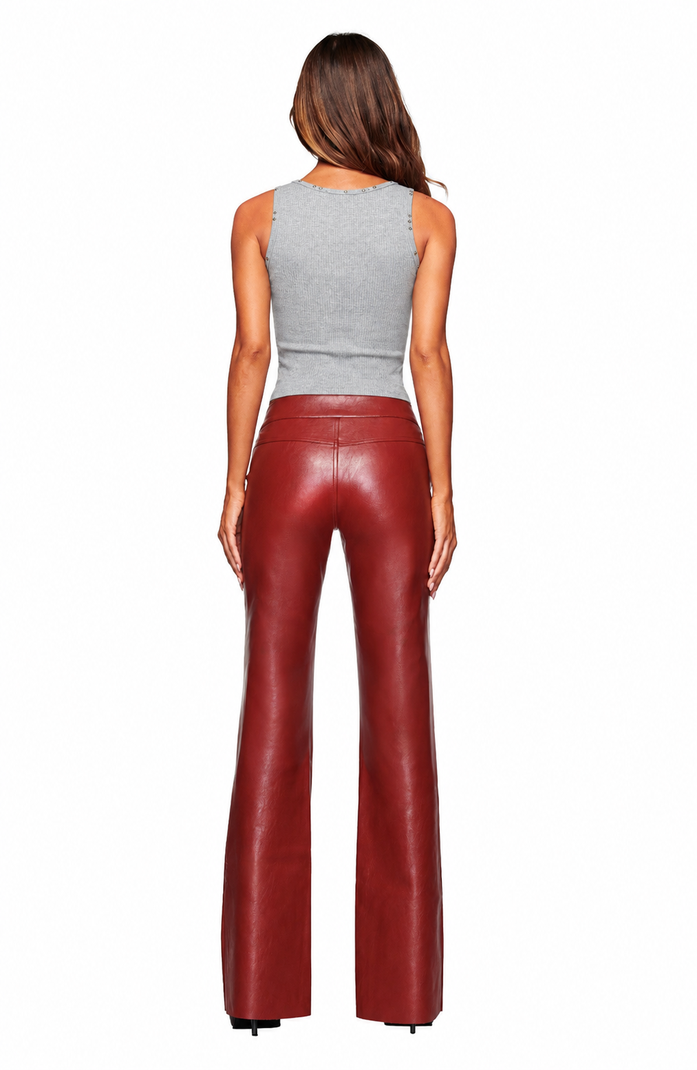 A woman with loose brown hair stands facing away against a white background, wearing a sleeveless gray top and I.AM.GIA REIKA PANT - DARK RED slim fit flare leg faux leather pants.