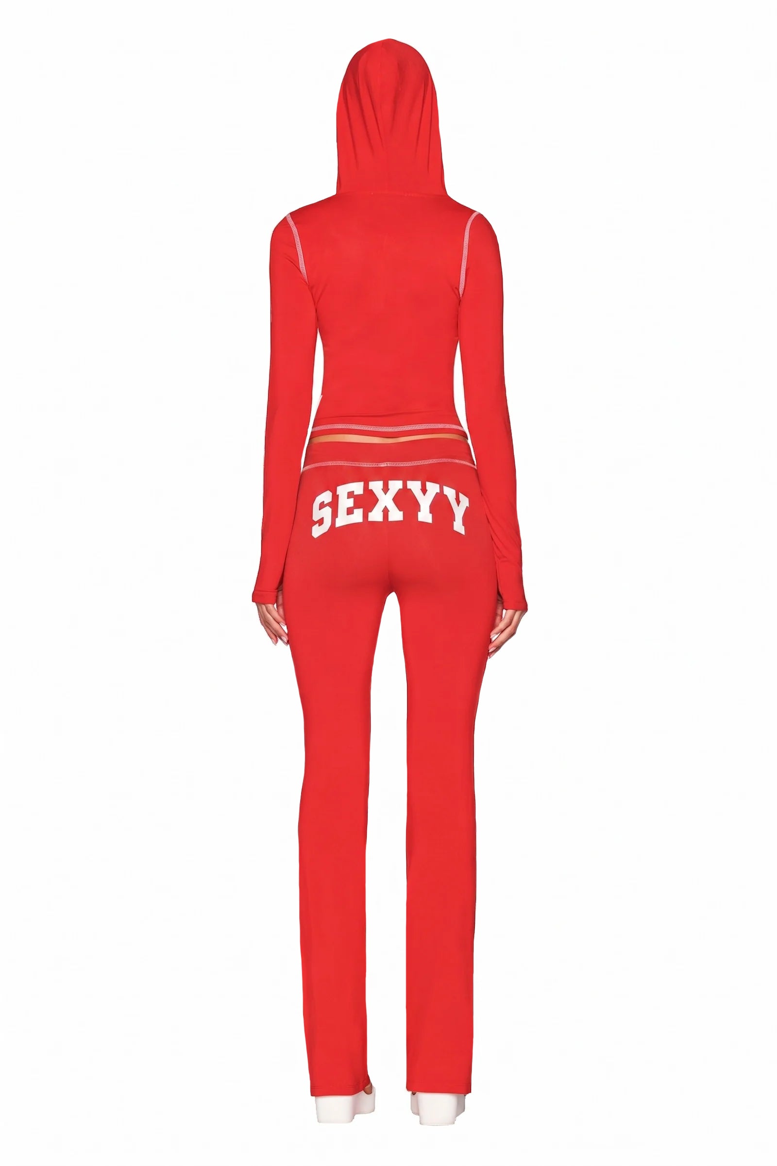 A person stands against a white background, wearing the form-fitting I.AM.GIA X SEXYY RED BLARE HOODIE - RED tracksuit. The pants display “SEXXY” in bold white letters across the back for a striking, confident look.
