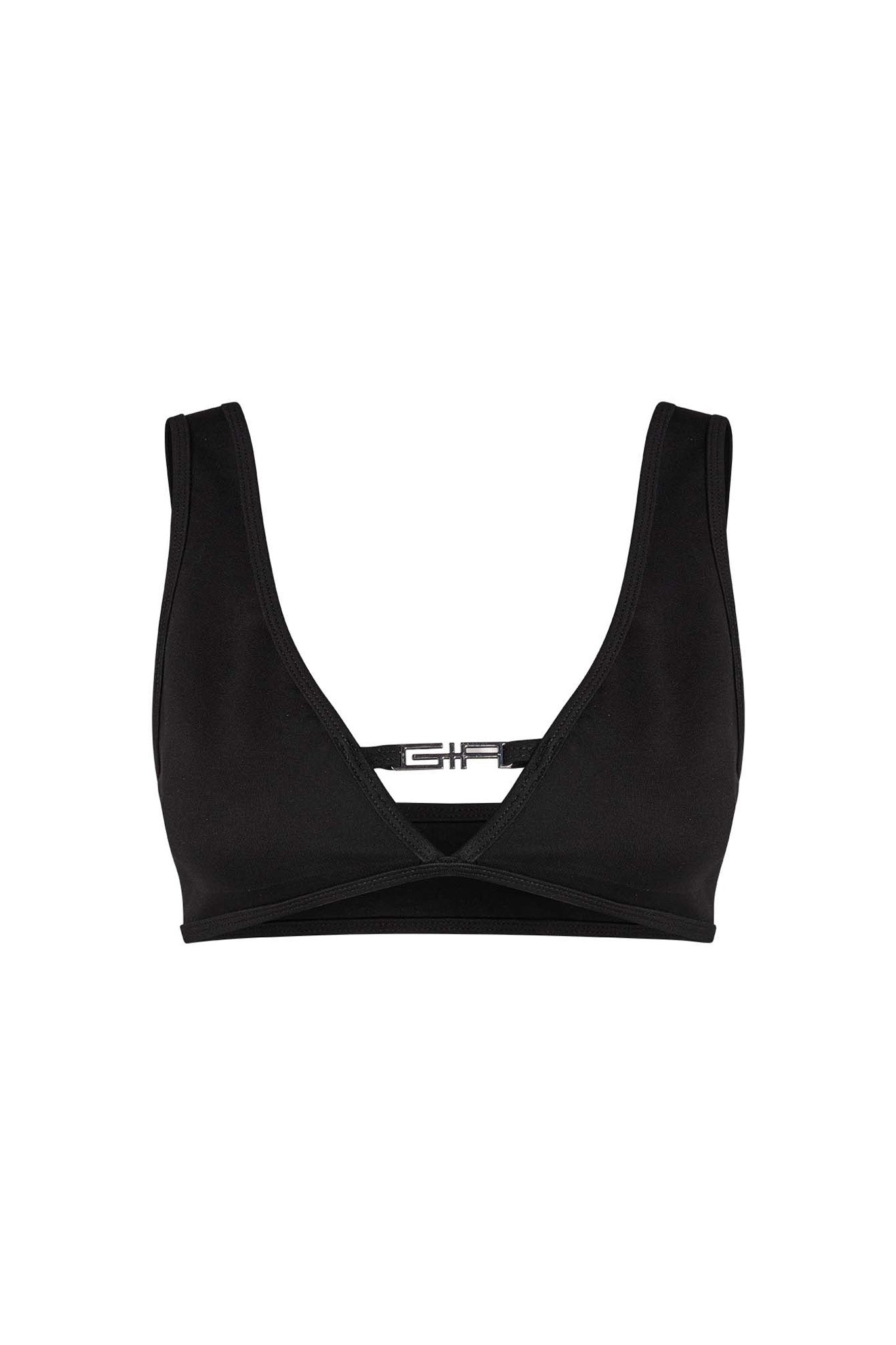 The LUCID TOP - BLACK by I.AM.GIA is a sleek black sports bra with a deep V-neck and wide shoulder straps. The back showcases a small horizontal strap adorned with the I.AM.GIA logo at the center. Made from smooth, stretchy fabric, it offers both support and comfort.