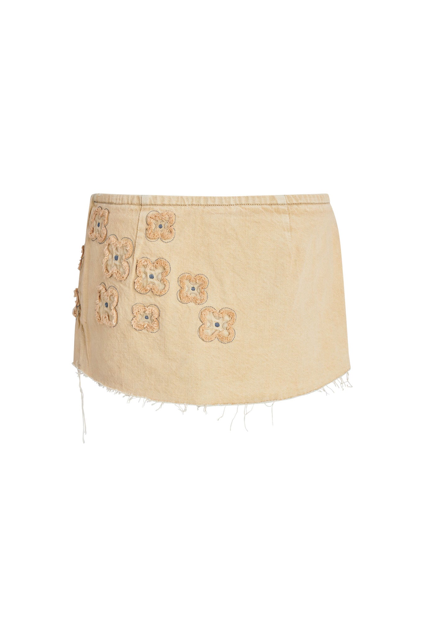 The FAUNA MINI SKORT - BEIGE : TAN DENIM by I.AM.GIA is a light beige, high-waisted mini skort adorned with small, floral crochet appliques on one side. The skort features a raw, frayed hem that adds a casual, bohemian touch.